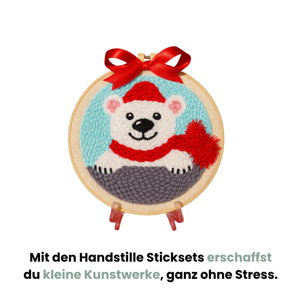 Punch Needle Weihnachtsmotiv mit Eisbär im Stickrahmen und roter Schleife, Text: ‚Mit den Handstille Sticksets erschaffst du kleine Kunstwerke, ganz ohne Stress.‘ Handstille Punch Needle Set für Anfänger – kreative DIY-Weihnachtsdeko ohne Stress.